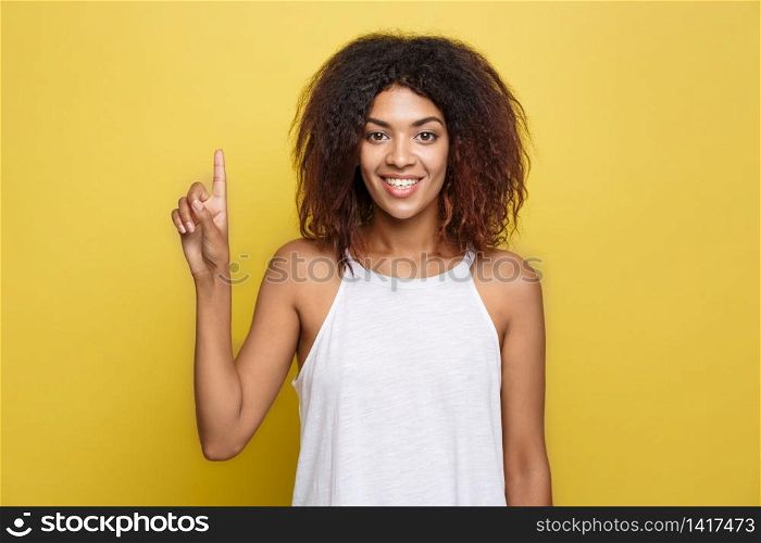 Beautiful attractive African American woman with curly afro hair thinking of something. Yellow studio background. Copy Space. Beautiful attractive African American woman with curly afro hair thinking of something. Yellow studio background. Copy Space.