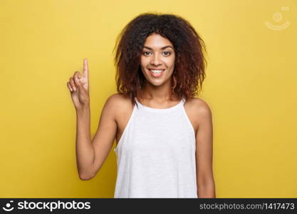 Beautiful attractive African American woman with curly afro hair thinking of something. Yellow studio background. Copy Space. Beautiful attractive African American woman with curly afro hair thinking of something. Yellow studio background. Copy Space.