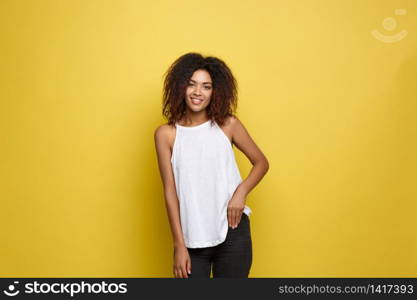 Beautiful attractive African American woman with trendy glasses posting over yellow studio background. Copy Space. Beautiful attractive African American woman with trendy glasses posting over yellow studio background. Copy Space.
