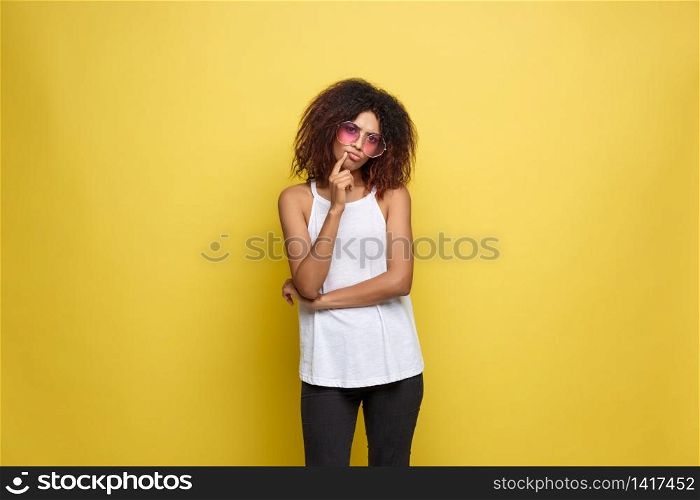 Beautiful attractive African American woman with trendy glasses posting over yellow studio background. Copy Space.. Beautiful attractive African American woman with trendy glasses posting over yellow studio background. Copy Space