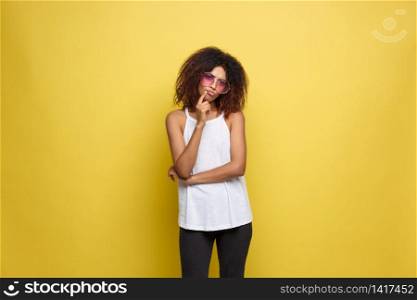Beautiful attractive African American woman with trendy glasses posting over yellow studio background. Copy Space.. Beautiful attractive African American woman with trendy glasses posting over yellow studio background. Copy Space