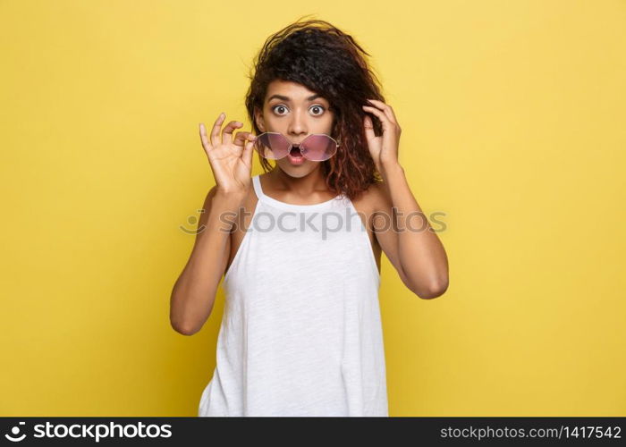 Beautiful attractive African American woman with trendy glasses posting over yellow studio background. Copy Space.. Beautiful attractive African American woman with trendy glasses posting over yellow studio background. Copy Space