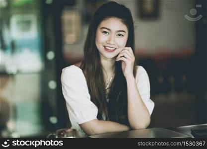 Beautiful Attractive Asian Business Woman smile and working with laptop in coffee shop feeling so happiness and comfortable,Business concept