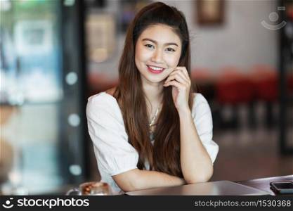 Beautiful Attractive Asian Business Woman smile and working with laptop in coffee shop feeling so happiness and comfortable,Business concept