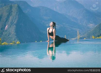 Beautiful Attractive Asian woman practice yoga Cobra pose on the pool above the Mountain peak in the morning in front of beautiful nature views in SAPA vietnam,Feel so comfortable and relax in holiday