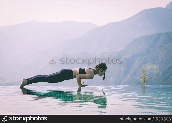 Beautiful Attractive Asian woman practice yoga Plank or Phalakasana Pose on the pool above the Mountain peak in the morning in front of beautiful nature views in SAPA vietnam,Feel so comfortable
