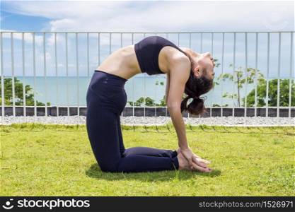 Beautiful Attractive Asian woman practice yoga Ustrasana Camel pose with beautiful sea feeling so happiness and comfortable