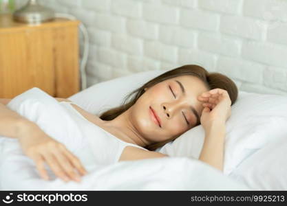 Beautiful Attractive Asian woman wearing Pajamas sleep close her eyes smile sleep and sweet dream on bed in bedroom in the morning feeling so relax and comfortable,Healthcare and Sleep Concept