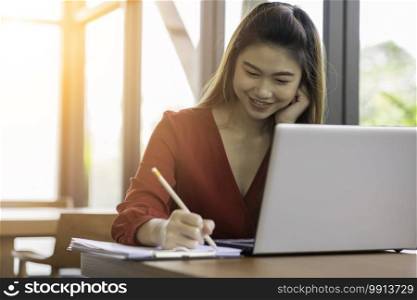 Beautiful Attractive Asian woman working with laptop smile and writing idea and requirement for success job outside office in coffee shop,Business Concept,Warm Tone