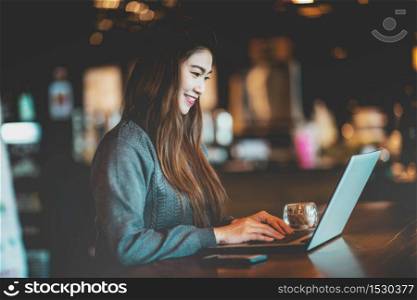 Beautiful Attractive Business Asian woman working with laptop and looking in monitor smile and have positive emotional feeling so happiness,Business Startup Concept,Warm Tone