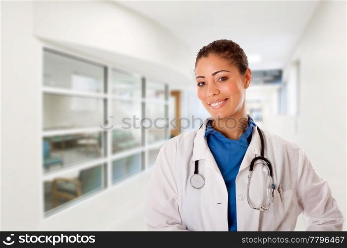 Beautiful attractive happy smiling female doctor physician nurse standing in hospital corridor hall way in front of patient consulting waiting area room.
