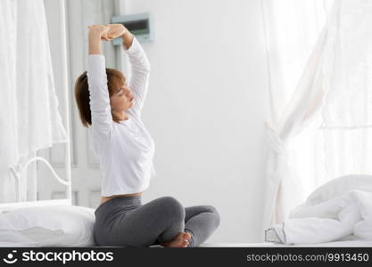 Beautiful Attractive Woman stretching her arm after wake up on bed feeling so fresh and relax in the morning,Healthcare Concept
