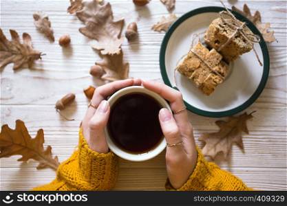 Beautiful autumn background - girl is holding a cup of tea in hands