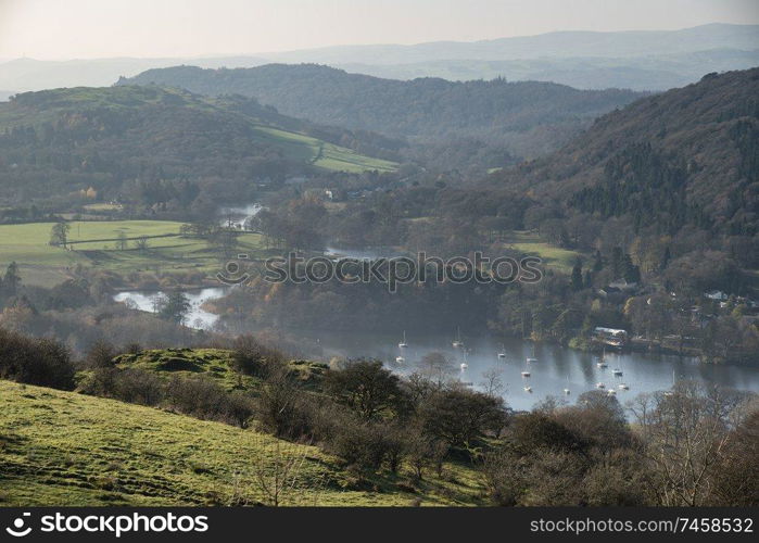 Beautiful Autumn Fall landscape image of view from Gummers How down onto Derwent Wter in Lake District