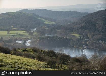Beautiful Autumn Fall landscape image of view from Gummers How down onto Derwent Wter in Lake District