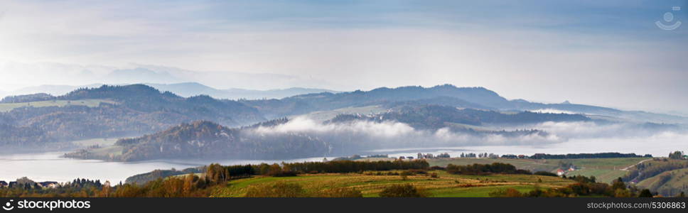 Beautiful autumn foggy morning panorama. Tatra mountains on background, Poland. Misty autumn lake.