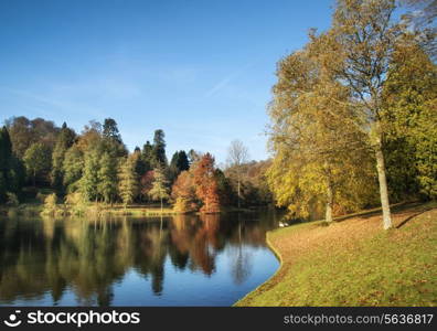 Beautiful Autumn lake landscape with vibrant colors reflected in still waters