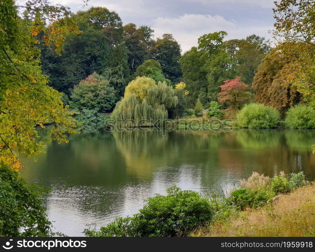 Beautiful autumn landscape of trees foliage and a Pond in West Yorkshire outside Leeds in the United Kingdom