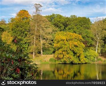 Beautiful autumn landscape of trees foliage and a Pond in West Yorkshire outside Leeds in the United Kingdom