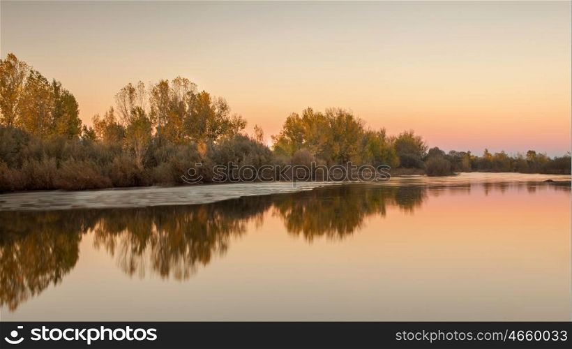 Beautiful autumn landscape. Trees along the banks of a river.