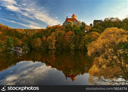 Beautiful autumn landscape with old castle Veveri at sunset and beautiful blue sky with clouds. Colorful nature background on autumn season. Brno - Czech Republic.