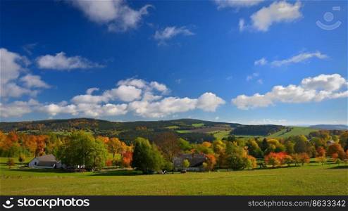 Beautiful autumn nature with landscape in the Czech Republic. Colorful trees with blue sky and sun. Background for fall and environment.
