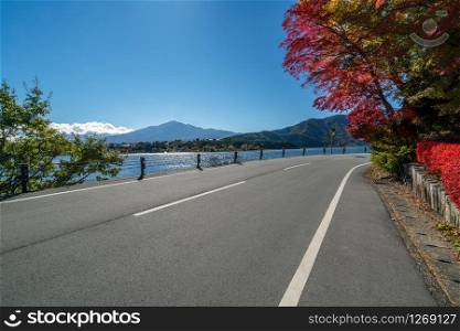 Beautiful autumn road scenery with lake and mountain landscape background. Concept of travel, transportation, road trip and freedom.