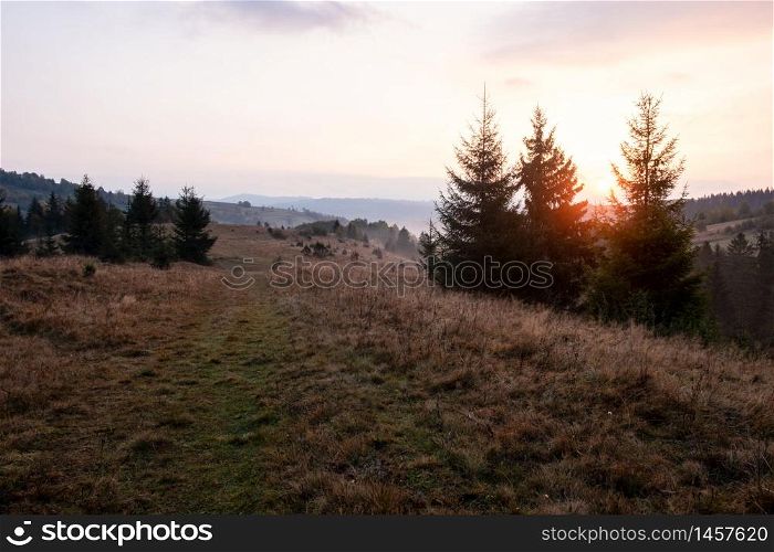 Beautiful autumn rural landscape with mountain and trees over amazing colors sky. Carpathian Mountains. Ukraine.. Beautiful autumn rural landscape with mountain and trees over amazing colors sky.