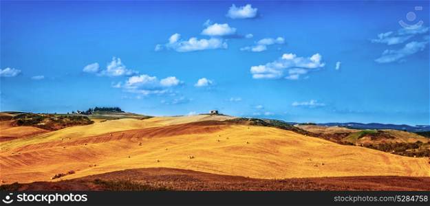 Beautiful autumnal landscape, dry golden hills with many haystack on it, panoramic farmland in Europe, harvest season concept