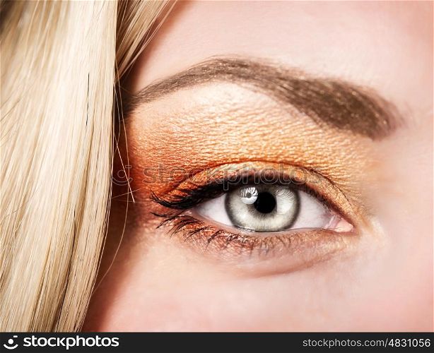 Beautiful autumnal makeup, female face part, stylish golden eyeshadow, fashionable look, beauty concept