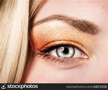 Beautiful autumnal makeup, female face part, stylish golden eyeshadow, fashionable look, beauty concept