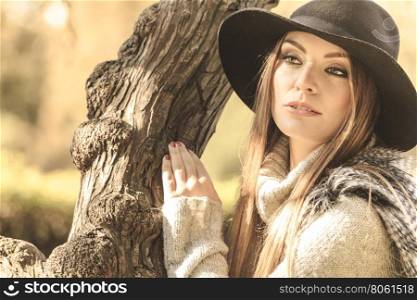 Beautiful autumnal woman in park. Young beauty woman wearing stylish autumnal clothes relaxing in park. Portrait of fashionable caucasian girl student resting on air.