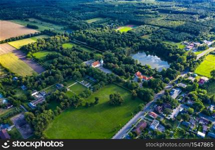 Beautiful avenue of trees of Nieborow Palace, a Baroque style residence in Poland. Colourful foliage in a French-design garden. Aerial view