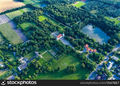 Beautiful avenue of trees of Nieborow Palace, a Baroque style residence in Poland. Colourful foliage in a French-design garden. Aerial view