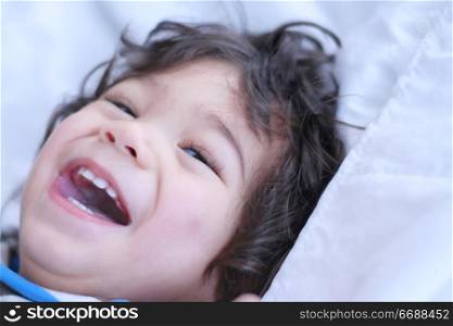 Beautiful baby boy smiling on bed