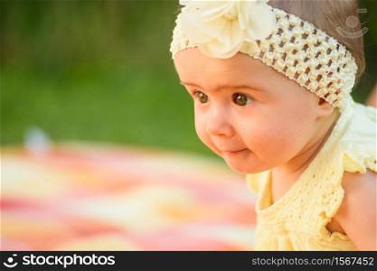 Beautiful baby girl infant in yellow band and dress summer day portrait