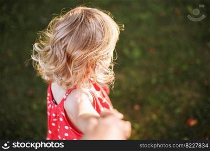 beautiful baby hair. the child holds the hand of the parent and plays