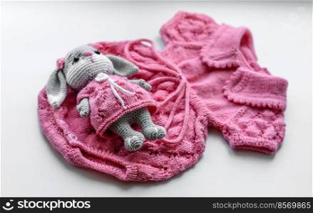 Beautiful baby knitted clothes and a toy for a newborn baby. Hobby, hand made. Beautiful baby knitted clothes and a toy for a newborn baby