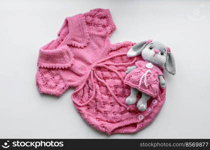 Beautiful baby knitted clothes and a toy for a newborn baby. Hobby, hand made. Beautiful baby knitted clothes and a toy for a newborn baby