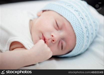 Beautiful baby with blue cap sleeping peacefully