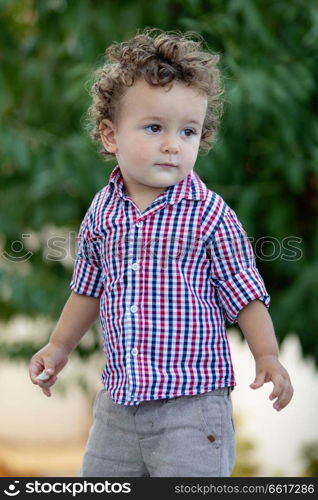 Beautiful baby with plaid shirt in the garden