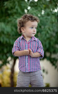 Beautiful baby with plaid shirt in the garden