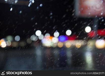 beautiful background of night lights, bokeh through wet glass