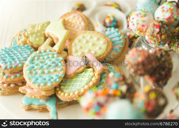 Beautiful background with colorful cookies and cake pops on white wooden desk
