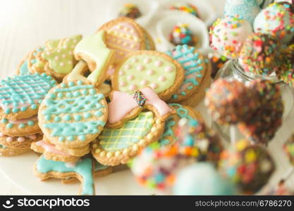 Beautiful background with colorful cookies and cake pops on white wooden desk