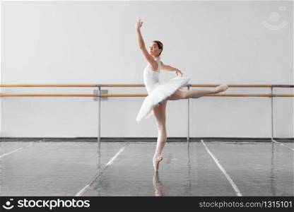 Beautiful ballerina rehearsal in ballet class, barre and white wall on background. Beautiful ballerina rehearsal in ballet class
