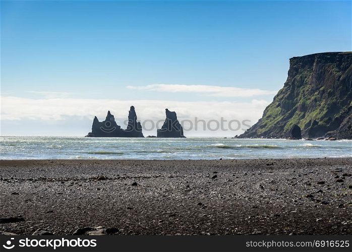 Beautiful Basalt rock Troll on black beach with blue sky, Reynisdrangar, Vik, Iceland