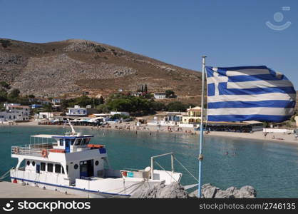 beautiful bay of Pserimos island with Greece flag