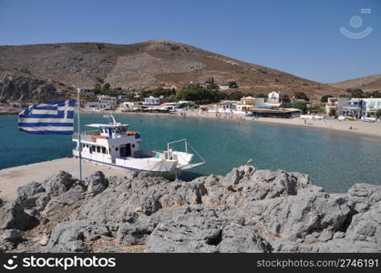 beautiful bay of Pserimos island with Greece flag