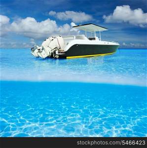 Beautiful beach and motor boat with white sand bottom underwater and above water split view